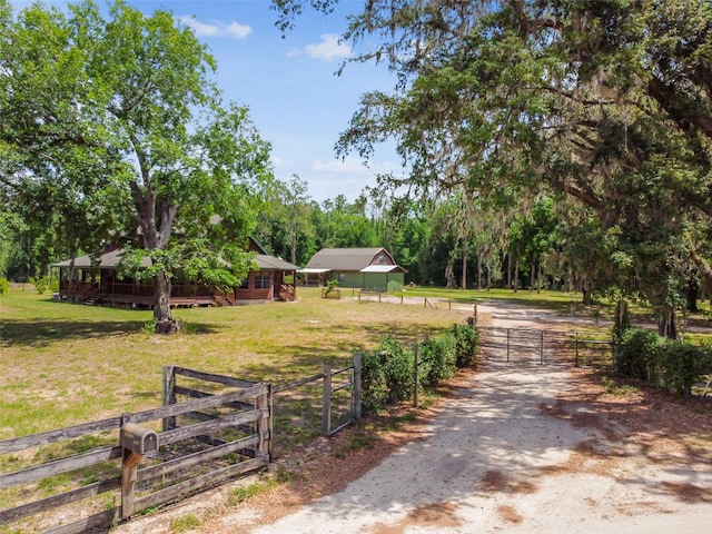 exterior space featuring a gate, a gated entry, and dirt driveway