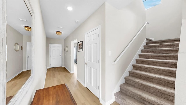 entrance foyer featuring baseboards, recessed lighting, light wood finished floors, and stairs