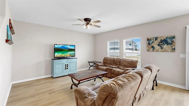 living area featuring light wood-style floors, baseboards, and ceiling fan
