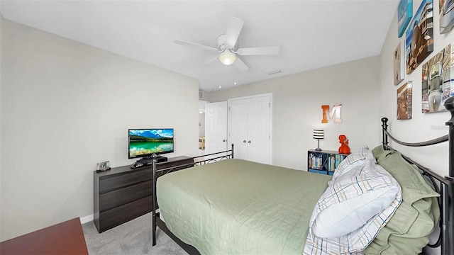 carpeted bedroom with a closet, baseboards, and a ceiling fan