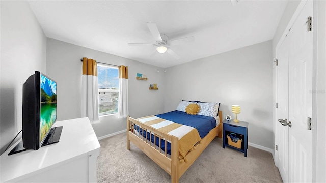 bedroom with baseboards, ceiling fan, and light carpet