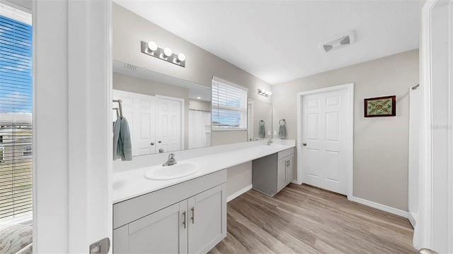 bathroom featuring a sink, baseboards, and wood finished floors