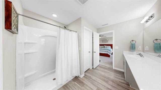 ensuite bathroom featuring a shower with curtain, visible vents, wood finished floors, vanity, and connected bathroom