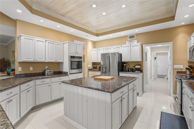 1750 Arabian Ln, Palm Harbor, FL 34685 - kitchen with a tray ceiling, appliances with stainless steel finishes, wood ceiling, a center island, and light tile patterned flooring