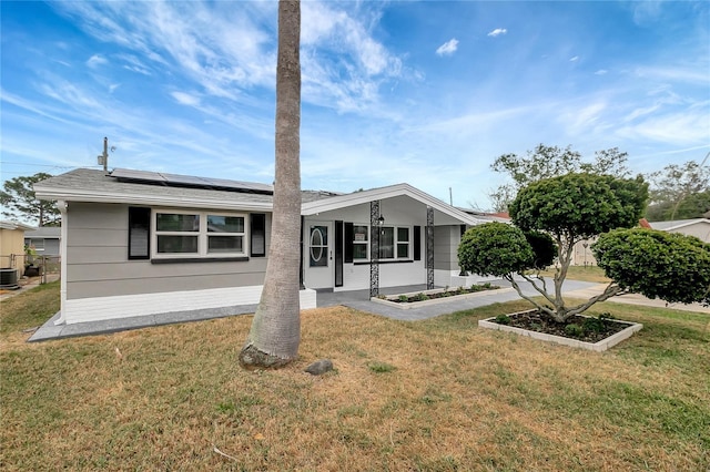 1516 Roundtree Rd, Holiday, FL 34690 - view of front of house featuring solar panels, central AC unit, and a front yard