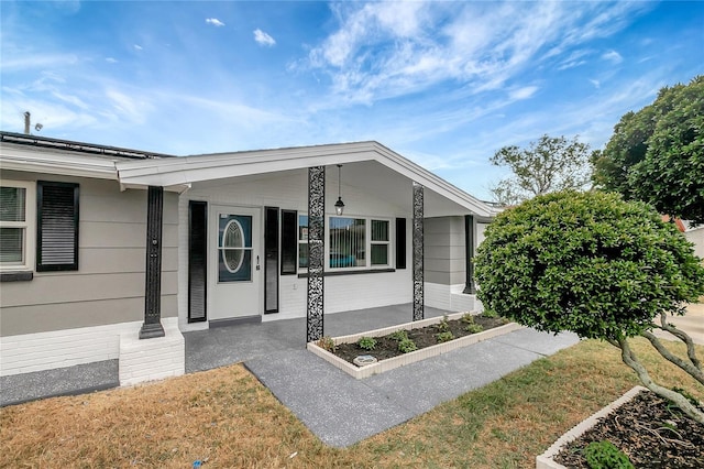 1516 Roundtree Rd, Holiday, FL 34690 - doorway to property with a lawn and covered porch