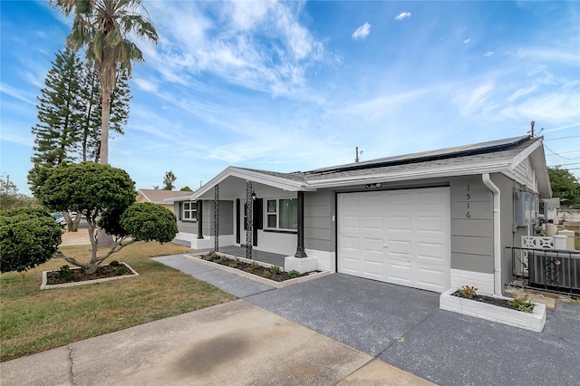 1516 Roundtree Rd, Holiday, FL 34690 - ranch-style house featuring covered porch, driveway, solar panels, a garage, and a front lawn
