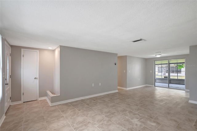 1516 Roundtree Rd, Holiday, FL 34690 - spare room featuring baseboards, a textured ceiling, and visible vents