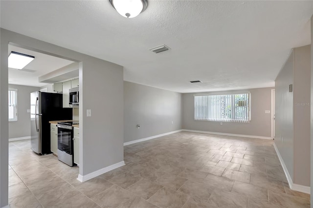 1516 Roundtree Rd, Holiday, FL 34690 - unfurnished room featuring baseboards, a wealth of natural light, and visible vents