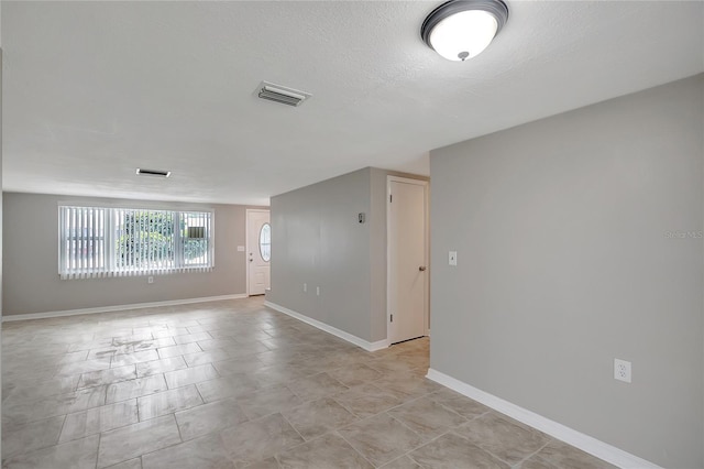 1516 Roundtree Rd, Holiday, FL 34690 - unfurnished room with baseboards, a textured ceiling, and visible vents