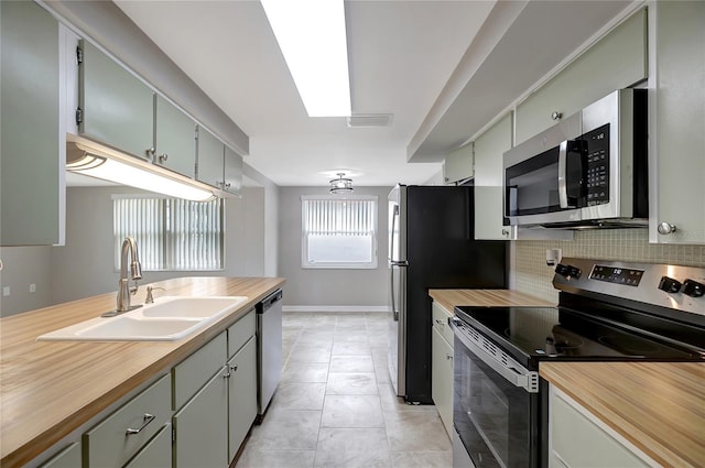 1516 Roundtree Rd, Holiday, FL 34690 - kitchen with a sink, butcher block countertops, stainless steel appliances, decorative backsplash, and visible vents