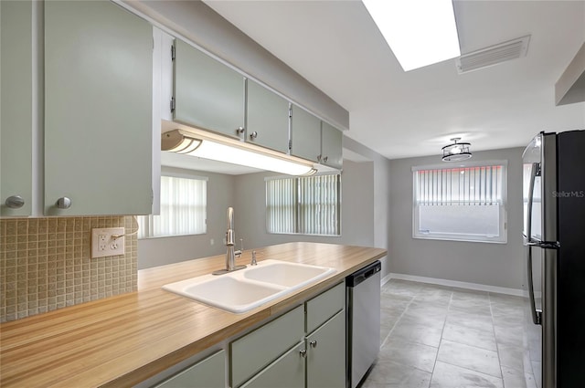 1516 Roundtree Rd, Holiday, FL 34690 - kitchen featuring visible vents, baseboards, light countertops, a sink, and appliances with stainless steel finishes