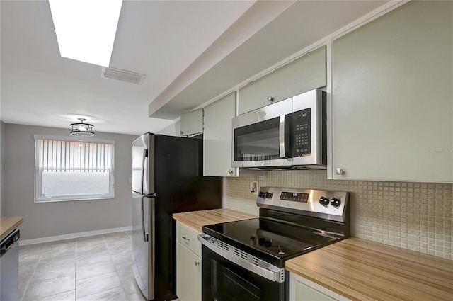 1516 Roundtree Rd, Holiday, FL 34690 - kitchen featuring visible vents, butcher block countertops, baseboards, tasteful backsplash, and stainless steel appliances