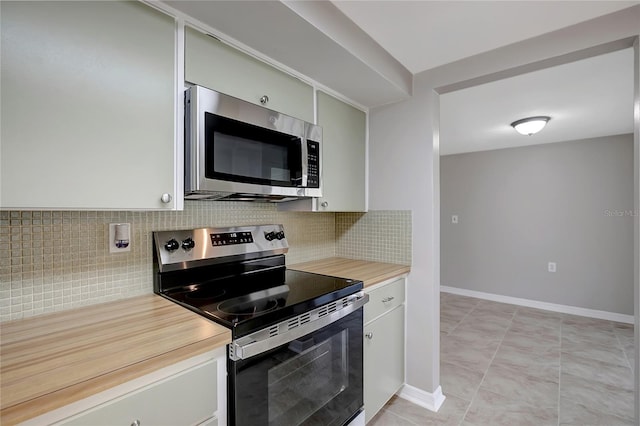 1516 Roundtree Rd, Holiday, FL 34690 - kitchen featuring white cabinets, appliances with stainless steel finishes, light countertops, baseboards, and decorative backsplash