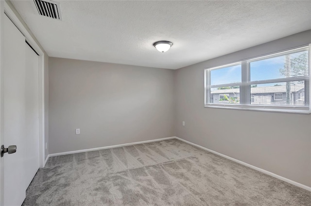 1516 Roundtree Rd, Holiday, FL 34690 - empty room featuring carpet flooring, a textured ceiling, visible vents, and baseboards