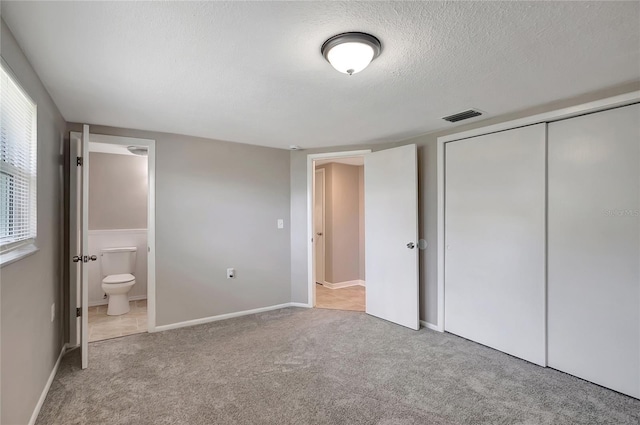 1516 Roundtree Rd, Holiday, FL 34690 - unfurnished bedroom with carpet flooring, visible vents, connected bathroom, and a closet