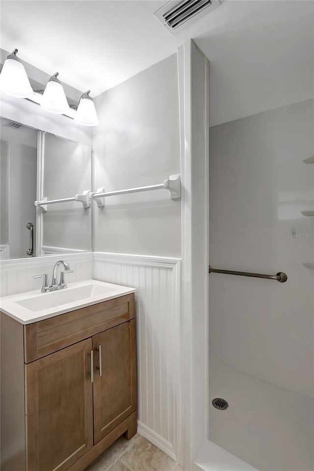 1516 Roundtree Rd, Holiday, FL 34690 - full bathroom with vanity, visible vents, tile patterned flooring, and a stall shower