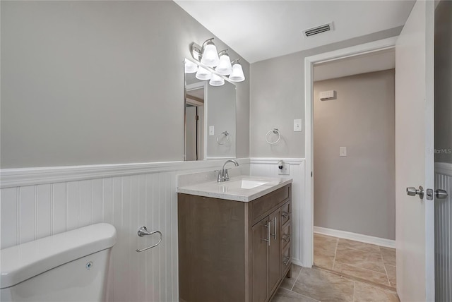 1516 Roundtree Rd, Holiday, FL 34690 - half bathroom with toilet, visible vents, a wainscoted wall, and vanity