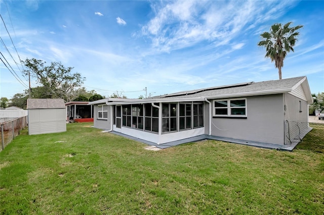 1516 Roundtree Rd, Holiday, FL 34690 - back of house with fence, a yard, a sunroom, and roof mounted solar panels
