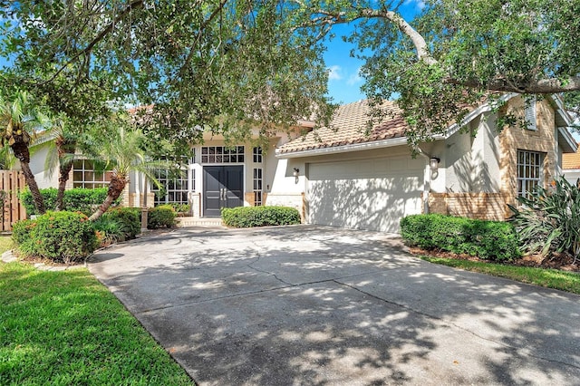 view of front facade with brick siding, a garage, stucco siding, and concrete driveway