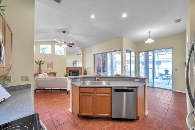 kitchen with ceiling fan, a sink, a fireplace, stainless steel appliances, and open floor plan