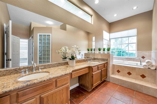 full bathroom featuring double vanity, tile patterned flooring, a sink, and a garden tub