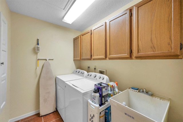 laundry room featuring baseboards, tile patterned floors, a sink, cabinet space, and independent washer and dryer