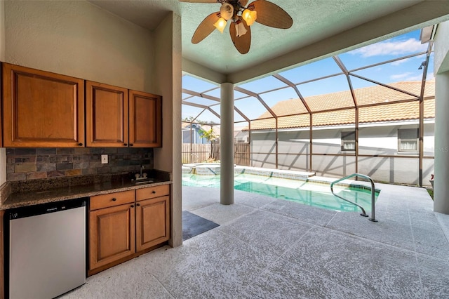 view of swimming pool with exterior kitchen, a patio, a fenced in pool, a ceiling fan, and glass enclosure
