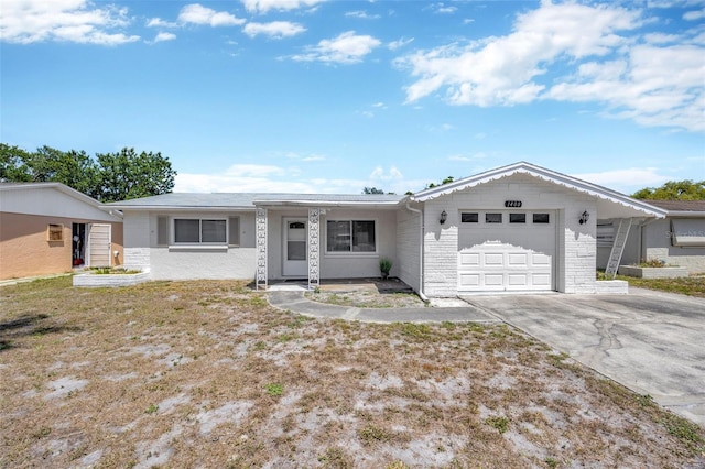 single story home with brick siding, a garage, and driveway