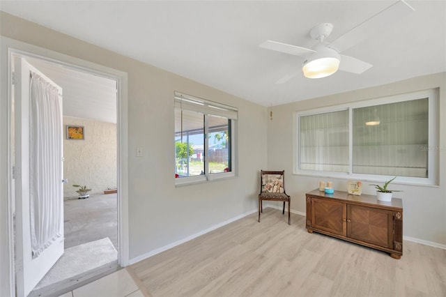 sitting room featuring baseboards, a ceiling fan, and wood finished floors