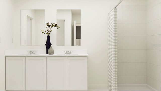 bathroom with double vanity, a tile shower, and a sink