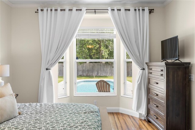 2512 Rustic Oaks Dr, Lutz, FL 33559 - bedroom with wood finished floors, multiple windows, crown molding, and baseboards