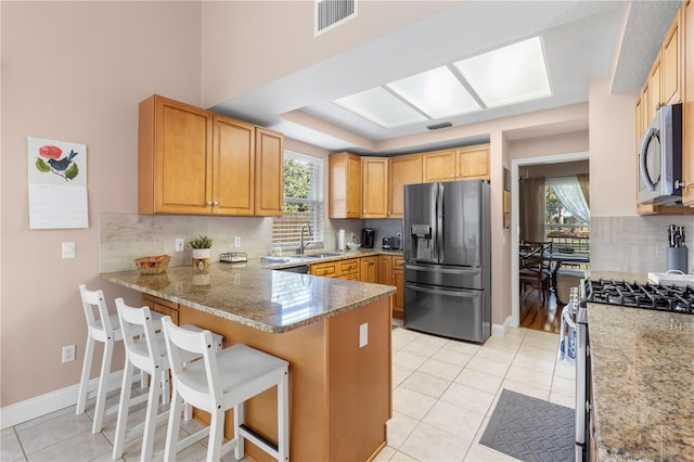 2512 Rustic Oaks Dr, Lutz, FL 33559 - kitchen with stainless steel appliances, a sink, a peninsula, and light tile patterned floors