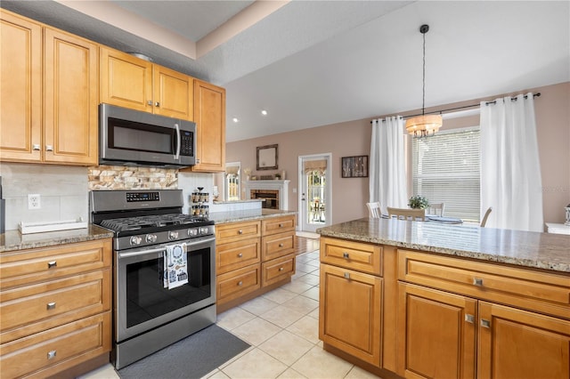 2512 Rustic Oaks Dr, Lutz, FL 33559 - kitchen with stainless steel appliances, a chandelier, light tile patterned flooring, backsplash, and light stone counters