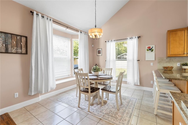 2512 Rustic Oaks Dr, Lutz, FL 33559 - dining area with a chandelier, baseboards, light tile patterned flooring, and high vaulted ceiling