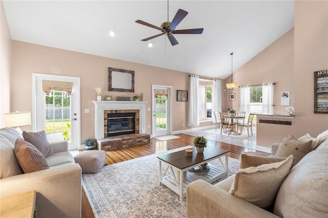 2512 Rustic Oaks Dr, Lutz, FL 33559 - living room with wood finished floors, a brick fireplace, a ceiling fan, high vaulted ceiling, and recessed lighting