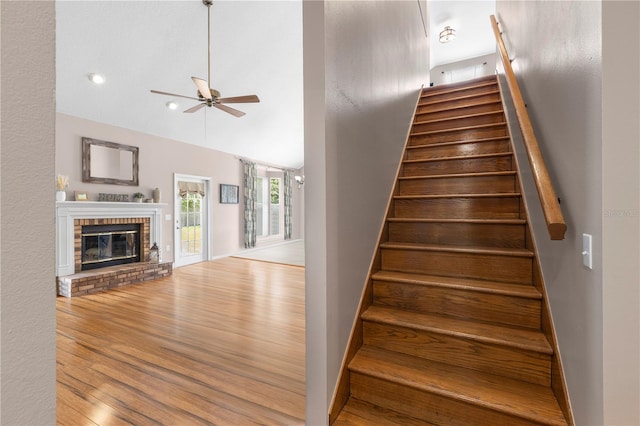 2512 Rustic Oaks Dr, Lutz, FL 33559 - stairway featuring a ceiling fan, wood finished floors, a brick fireplace, and lofted ceiling