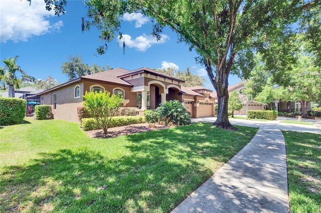 mediterranean / spanish home featuring concrete driveway, stucco siding, an attached garage, and a front yard