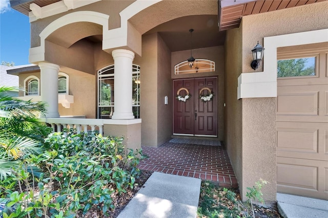 doorway to property with a porch and stucco siding