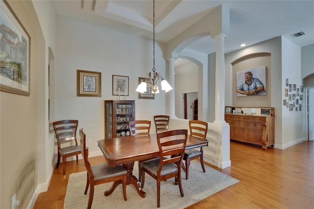 dining room with arched walkways, visible vents, decorative columns, and a chandelier