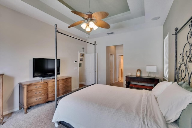 bedroom featuring carpet flooring, a ceiling fan, visible vents, and a raised ceiling