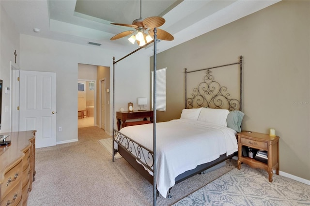 bedroom with visible vents, baseboards, light colored carpet, connected bathroom, and a ceiling fan