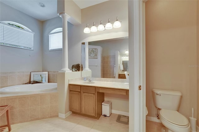 full bathroom with tile patterned flooring, a garden tub, decorative columns, vanity, and toilet