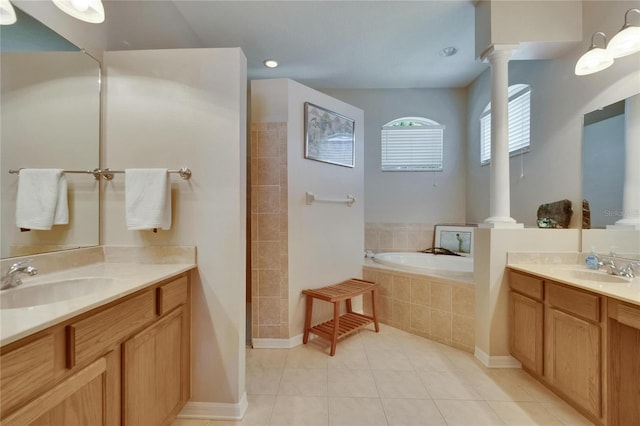 bathroom featuring ornate columns, tile patterned floors, a sink, and a bath