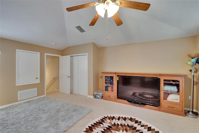carpeted living area with baseboards, visible vents, ceiling fan, and vaulted ceiling