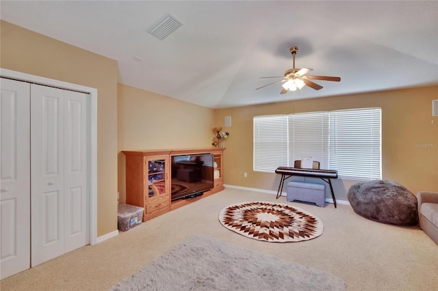 carpeted living area featuring baseboards, a ceiling fan, and visible vents