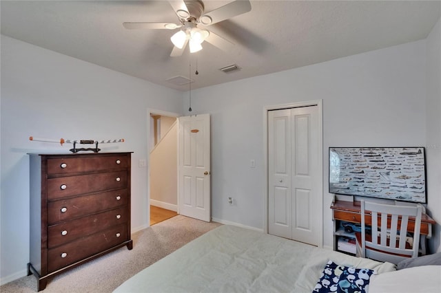 bedroom featuring ceiling fan, visible vents, light colored carpet, baseboards, and a closet