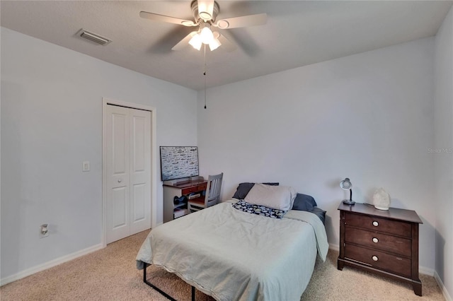 bedroom with baseboards, visible vents, light carpet, and a closet