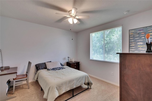 bedroom featuring baseboards, ceiling fan, and light carpet