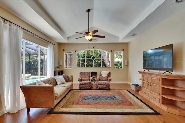 living room featuring visible vents, a ceiling fan, lofted ceiling, and wood finished floors